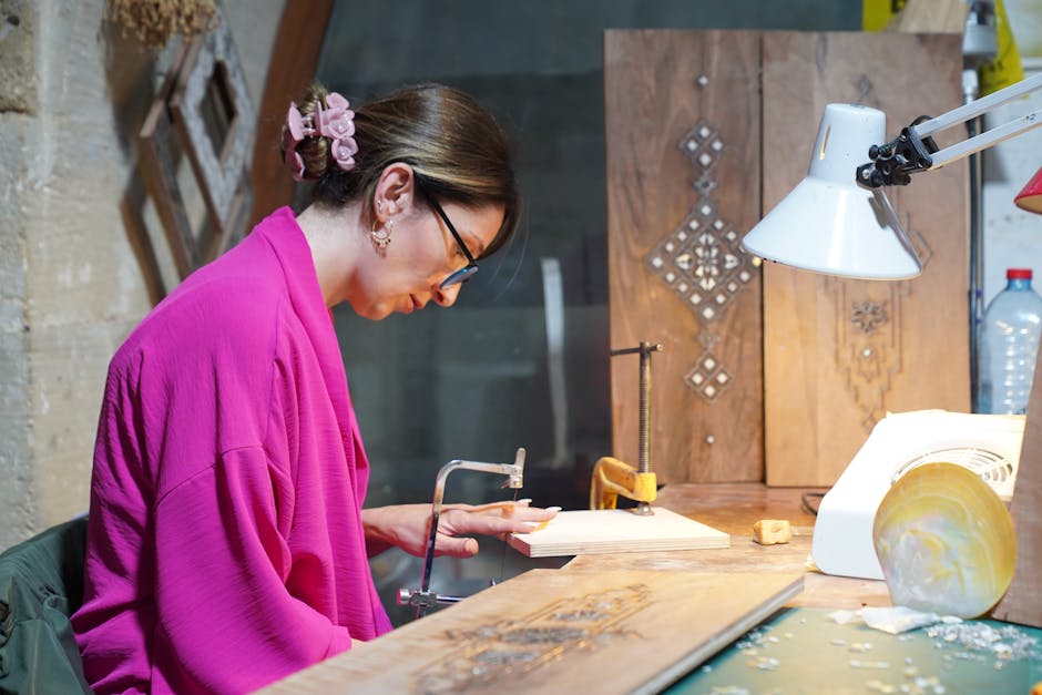 Kunsthandwerkerin im Piemont sägt Holzdetail an einem Werkstück