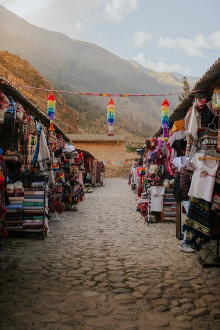 Allée pavée bordée d'étals textiles colorés, marché artisanal de Piémont
