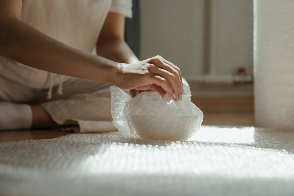 Mani che avvolgono una ciotola artigianale fragile con pluriball in Piemonte