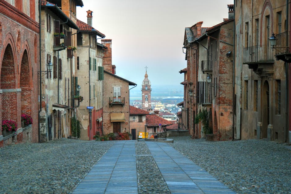 Piazza lastricata di un borgo piemontese illuminata dalla luce del mattino