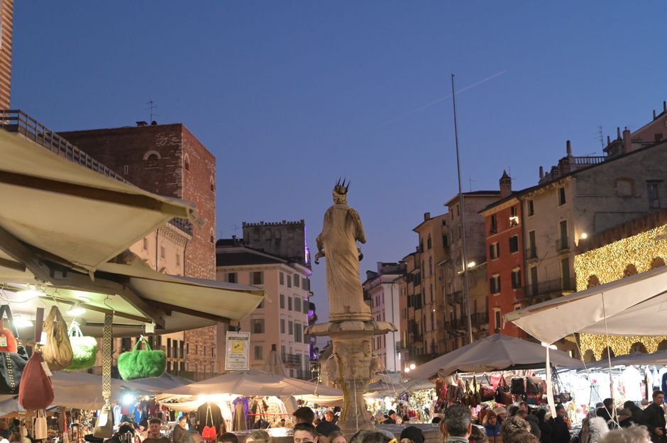 Avondmarkt met kraampjes en fontein op een plein in Piemonte