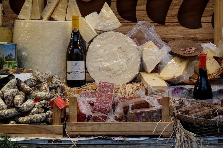 Käse- und Wursttheke mit Weinflaschen und gereiften Käselaiben im Piemont