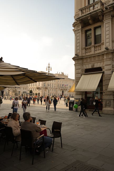 Straßencafé mit Gästen und Spaziergängern auf einem Platz in Turin, Piemont