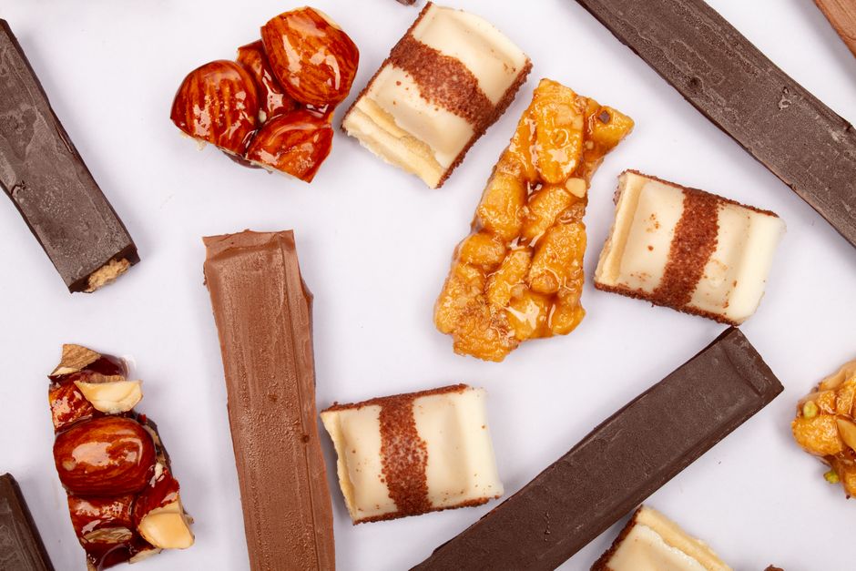 Assorted chocolates and pralines arranged on white surface, typical of Piedmont