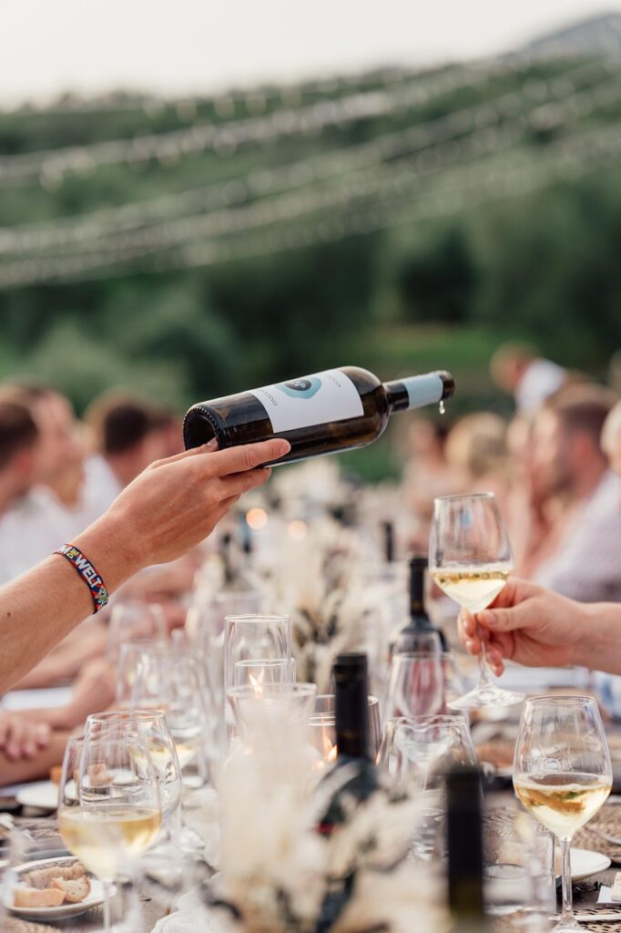Servizio di vino bianco durante degustazione all'aperto in Piemonte