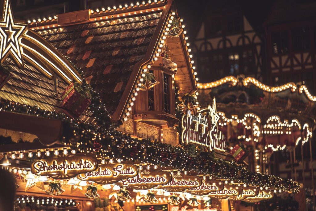 Illuminated wooden market stalls decorated with lights at a Piedmont Christmas market