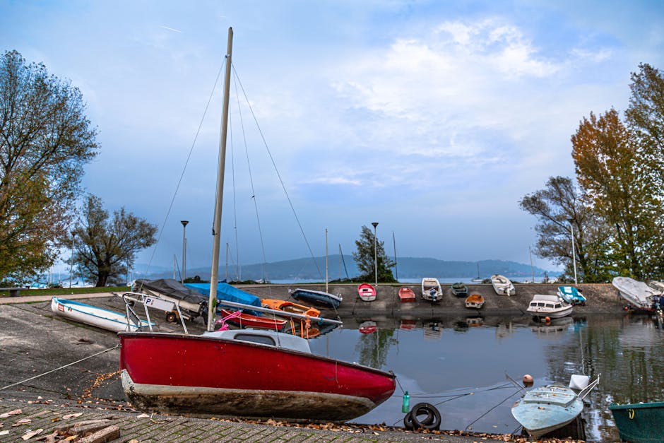 Red sailboat and small boats moored in a Piedmont lake harbor