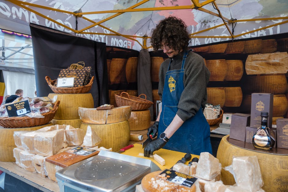 Händler schneidet Parmesan am Stand auf einem Markt im Piemont