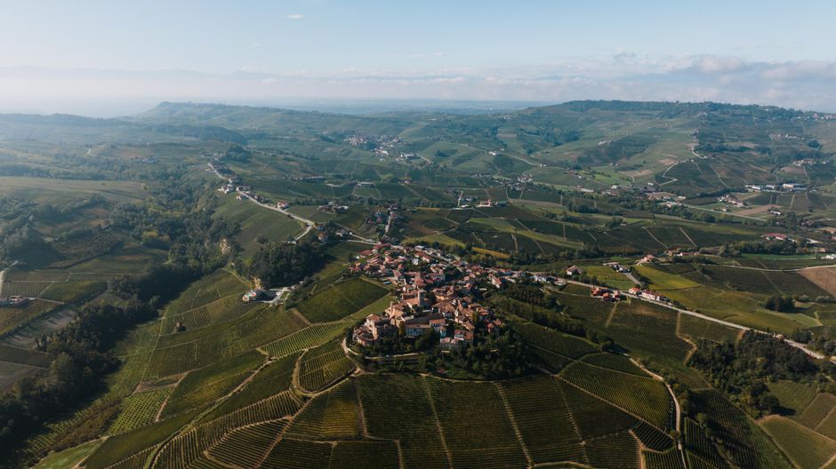 Luchtbeeld van uitgestrekte wijngaarden en gehuchtjes in Piémont