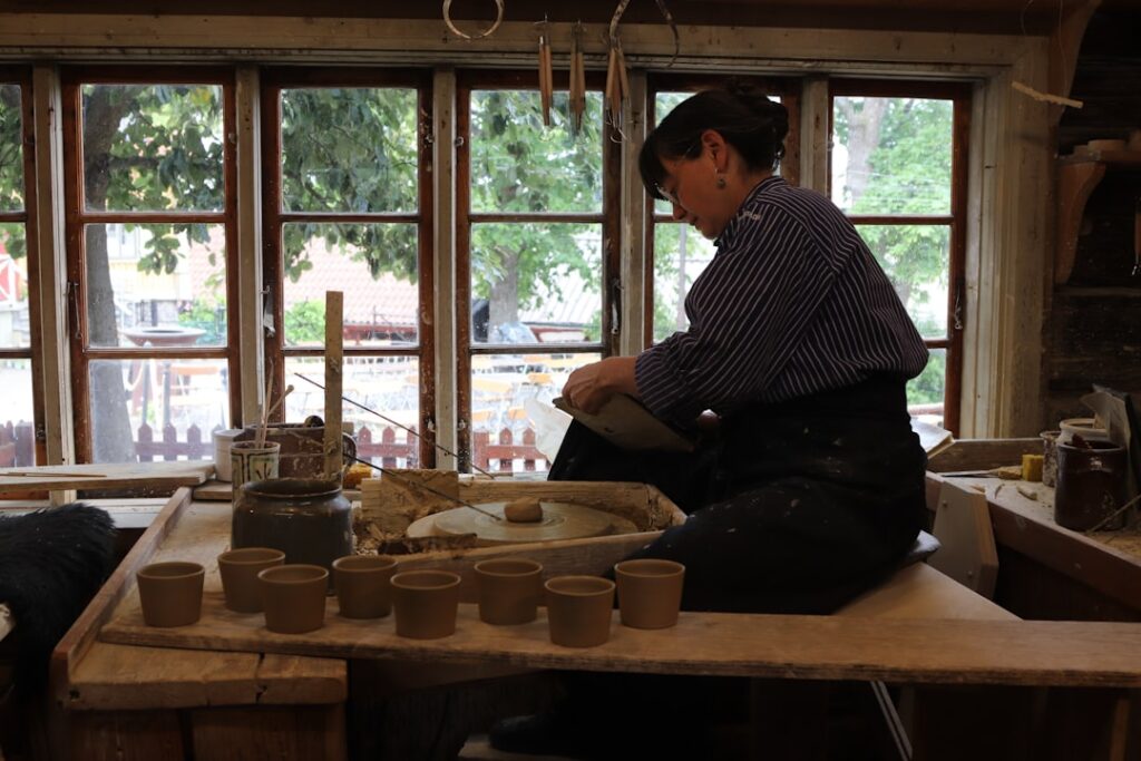Potter shaping clay cups on a wheel in Civita Castellana workshop
