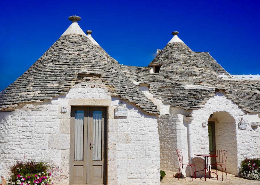 Wit trullo met conische stenen daken en terrasstoelen in Latium