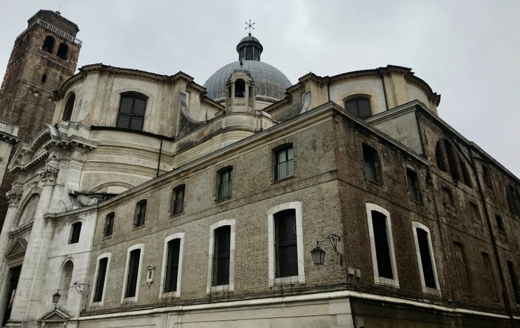 façade d'une grande église en pierre avec dôme et clocher