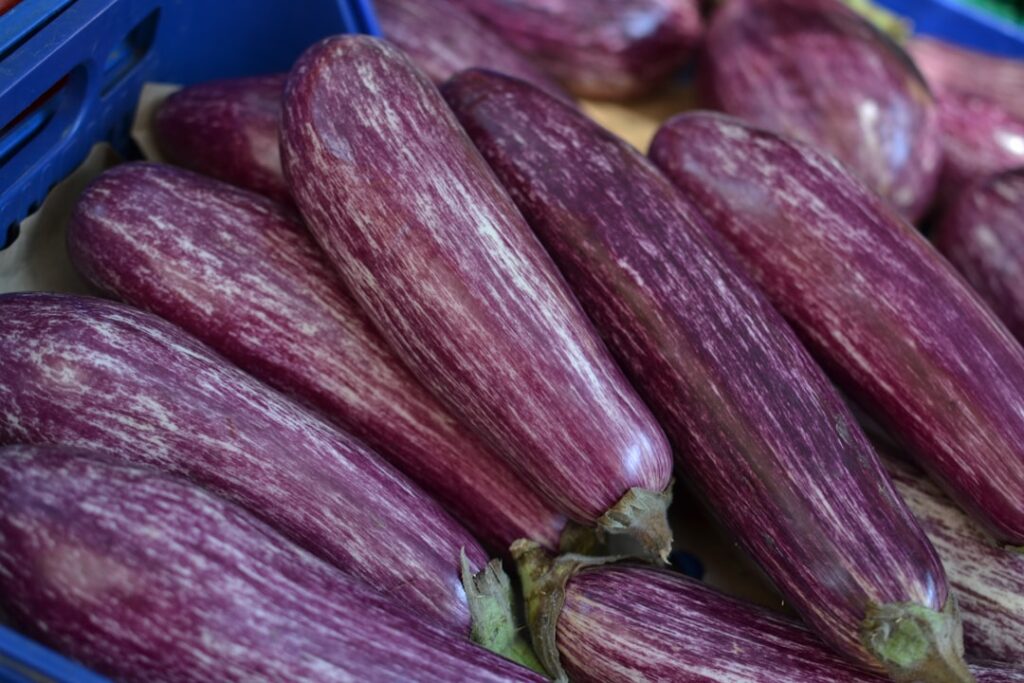 Gestreifte violette Auberginen liegen in einer Kiste auf römischem Markt