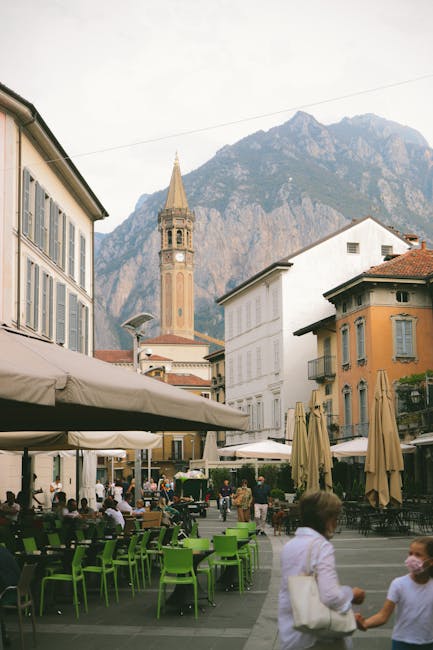 Place animée d'une ville du Latium, terrasses et clocher devant les montagnes