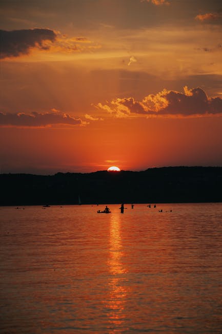 Coucher de soleil sur le lac d'Albano, barques silhouettes et reflet orange