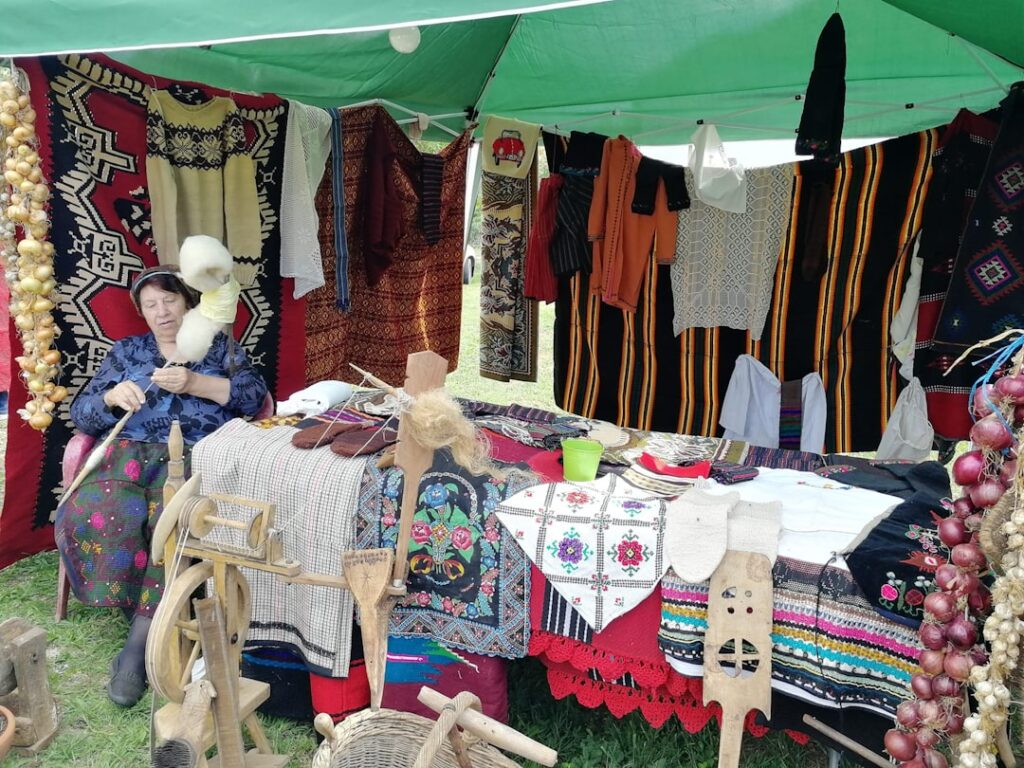 Marktkraam met handwerk en vrouw die wol spint in Latium