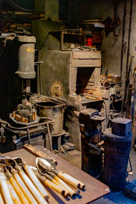 Rommelige werkplaats met aambeeld, gereedschap en lepels op tafel in Latium.