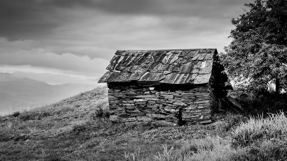 Stone shepherd's hut on grassy hillside in Latium under cloudy sky