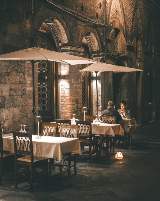 Terrasse nocturne sous arcades avec tables dressées, dîner tranquille en Latium.