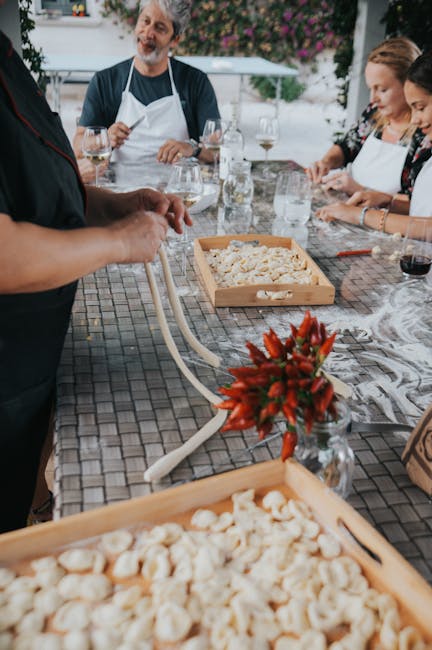 Groep deelnemers kneden en vormen pasta buiten aan tafel in Latium workshop