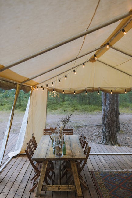 Interno tenda con tavolo rustico e lucine, campeggio nel Lazio