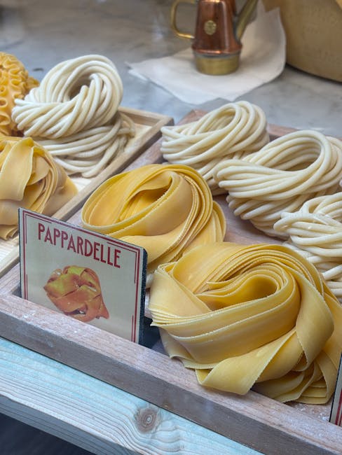 Houten bakken met nestjes pappardelle en andere pasta's op markt in Latium