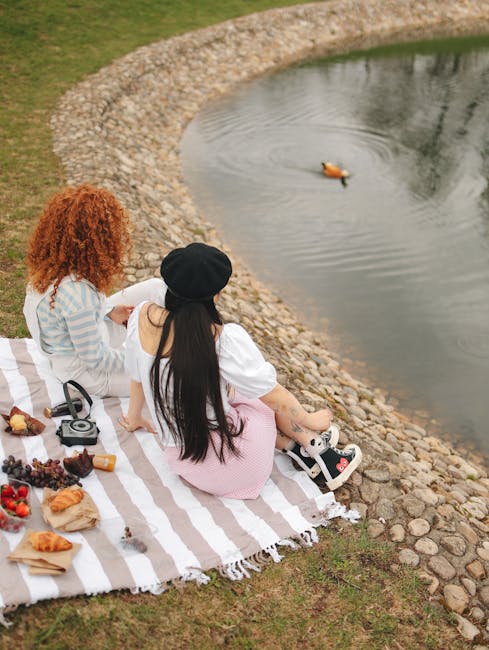Twee vrouwen picknicken op een kleed bij een vijver in Latium
