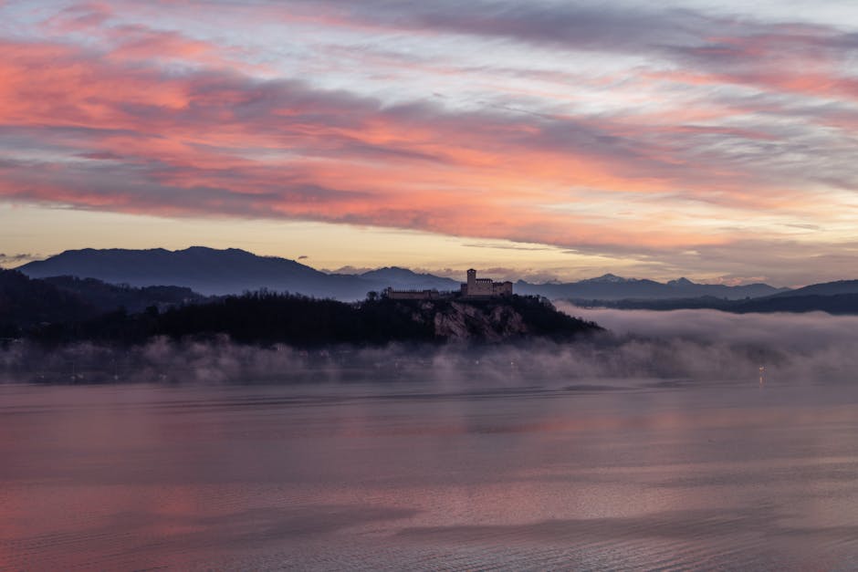 Kasteel op rots bij Meer van Bracciano in Latium, roze ochtendmist