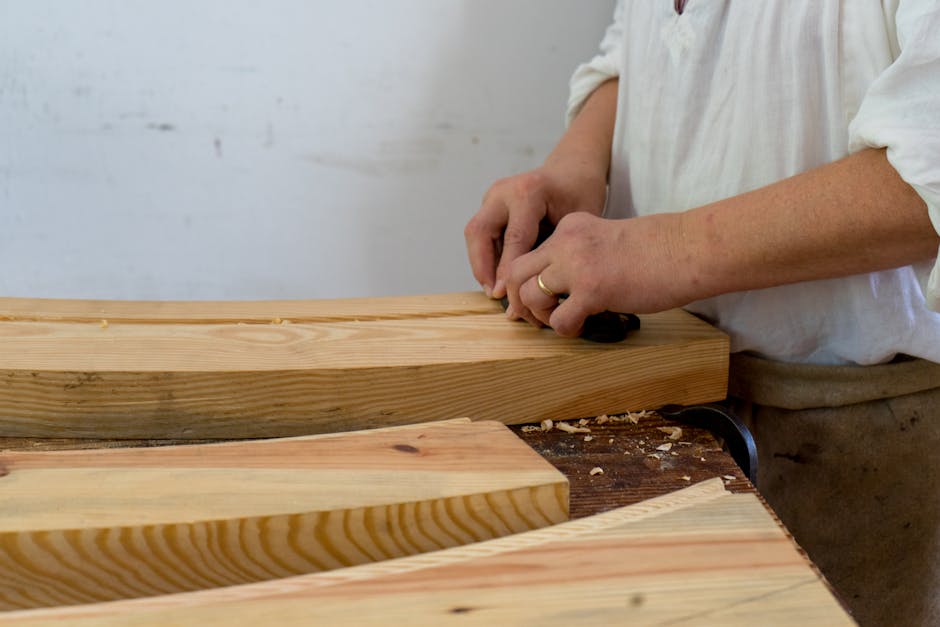 Mani che piallano assi in legno su banco da lavoro