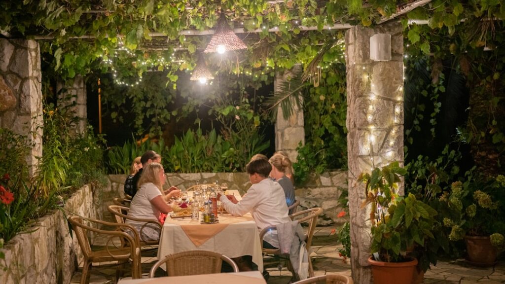 Cena conviviale sotto pergolato illuminato al B&B nel Lazio
