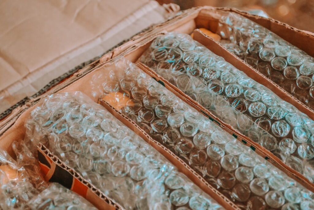 Hands packing wine bottles into protective sleeves