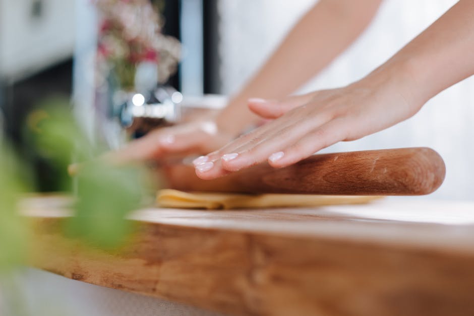 Handen rollen vers pastadeeg met deegroller op houten werkblad in Latium