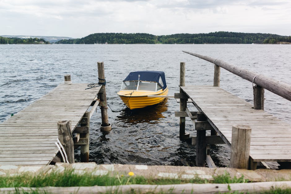 Gelbes Motorboot liegt am hölzernen Steg am Bracciano-See