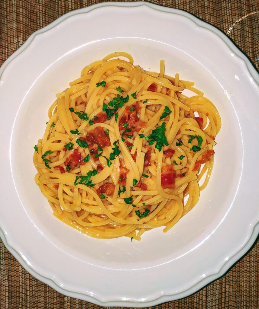 Bord pasta met stukjes pancetta en peterselie, typische Latiumse smaak