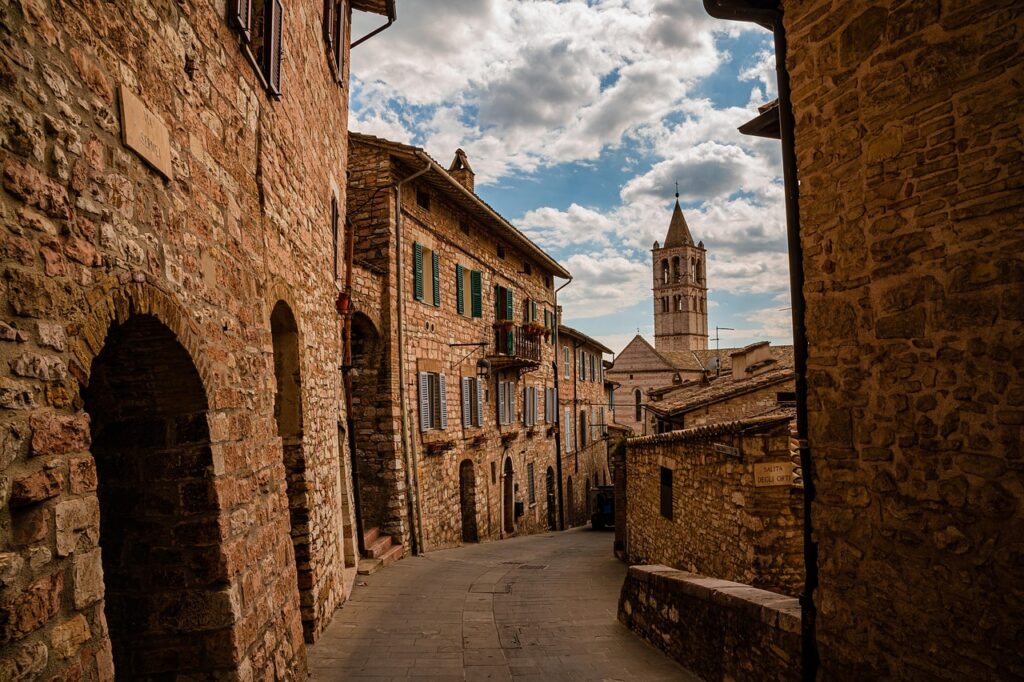 Schmale gepflasterte Gasse mit Steinbauten und Turm in Viterbo, Latium