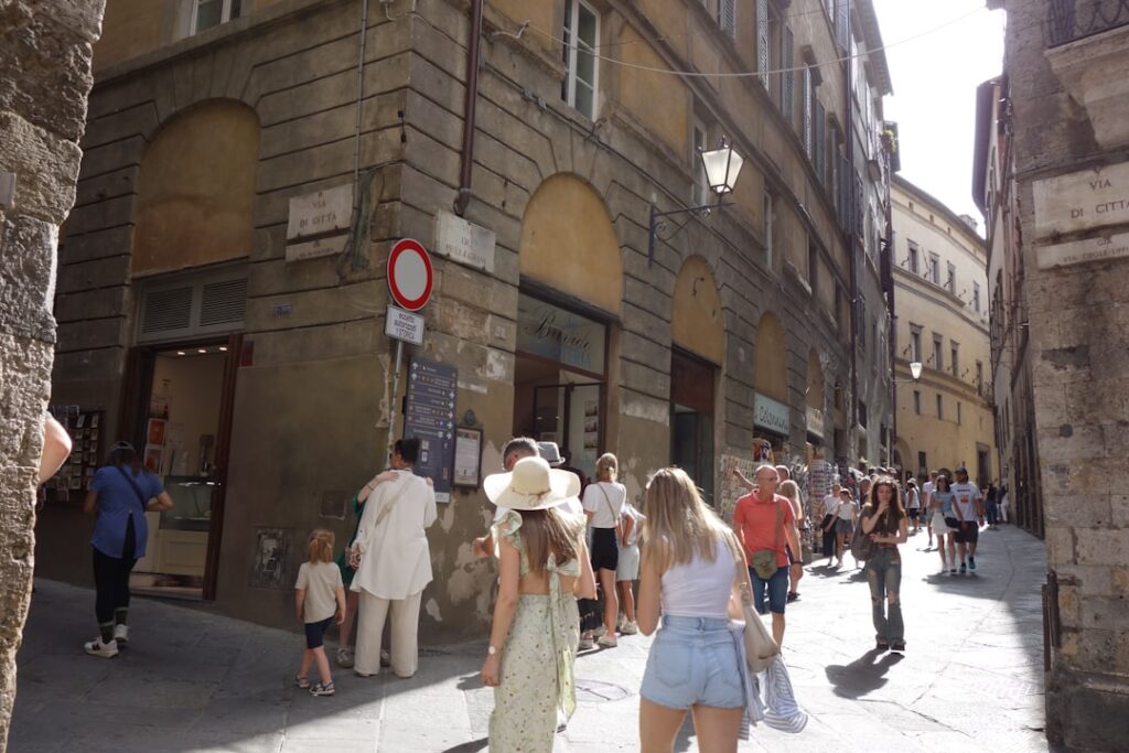 Vista di Corso Vannucci con negozi e passanti nel pomeriggio
