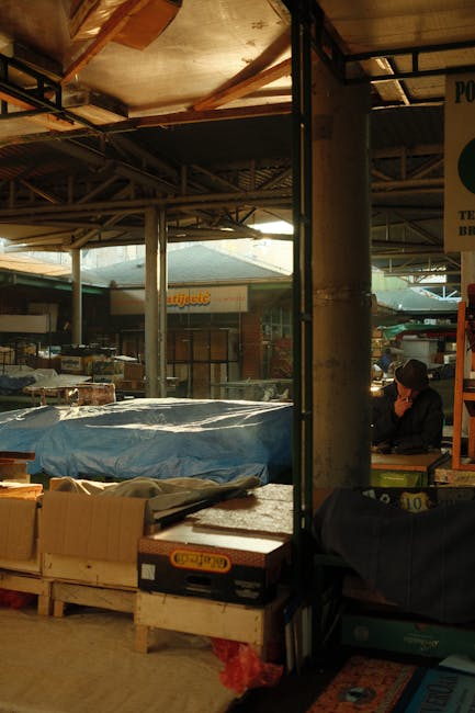 Interno del mercato coperto di Perugia con bancali coperti e venditore
