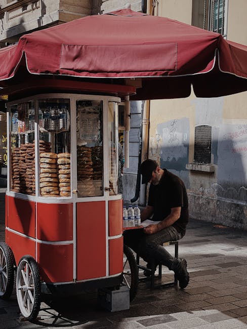 Carretto rosso con ciambelle e venditore seduto lungo una via di Perugia