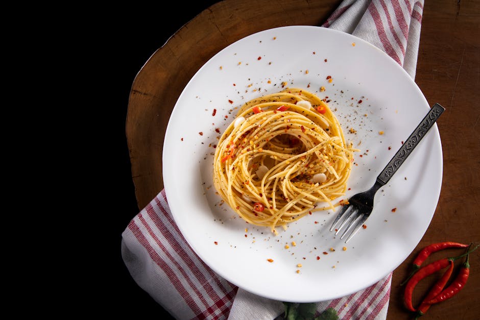 Plate of spaghetti aglio, olio e peperoncino topped with crispy prosciutto