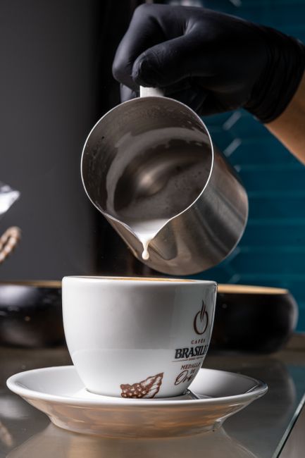 Barista gießt Cappuccino im Grand Hotel Brufani