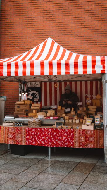 Marktstände in historischen Gassen mit Käseverkäufern