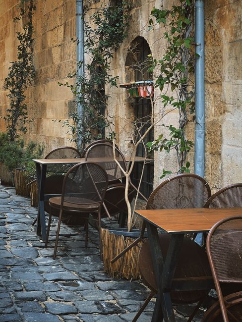 Malerische Kopfsteinpflastergasse mit Café-Tischen am Morgen