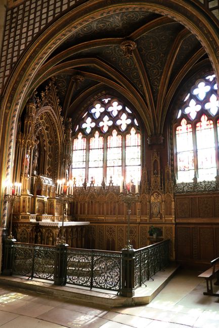 Innenraum einer kleinen Kapelle bei Nacht mit warmem Kerzenlicht