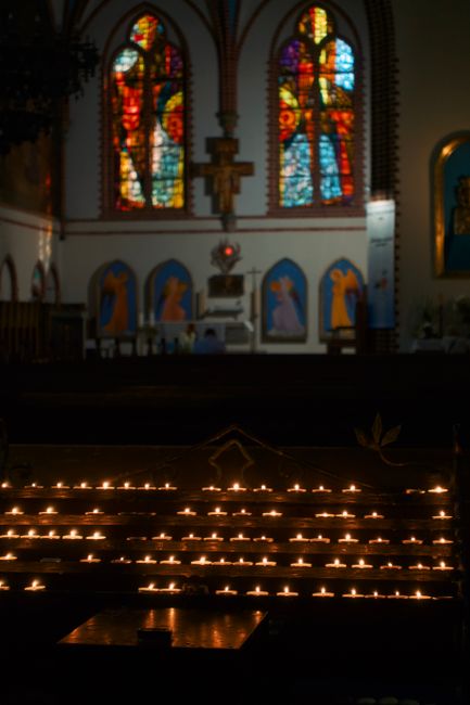 Kircheninnenraum bei Nacht mit Kerzenlicht und ruhigem Gottesdienst
