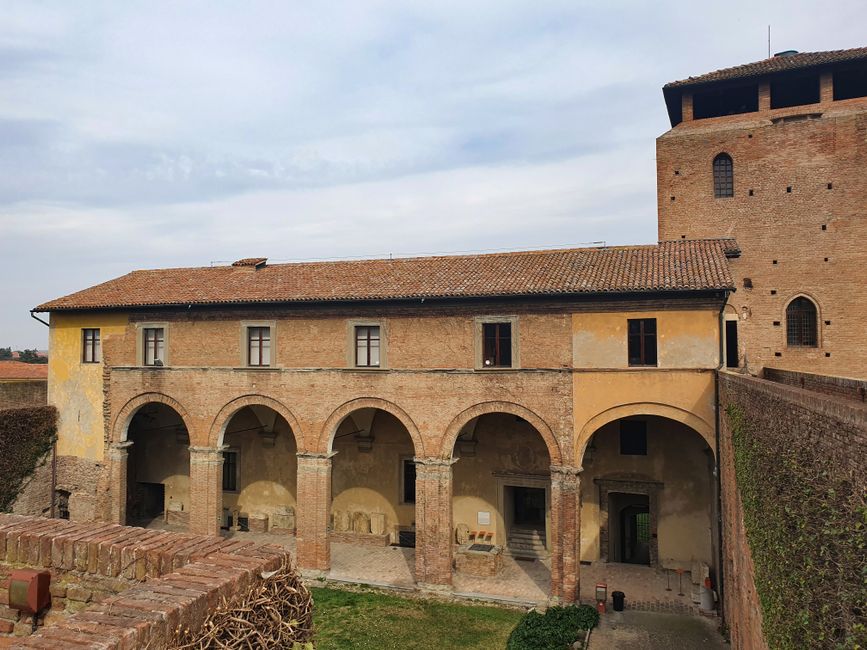 Rode bakstenen kloosterarcaden en binnenhof van een historisch gebouw in Perugia