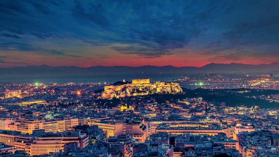 Cityscape of Athens at sunset with the Acropolis silhouetted against dusk