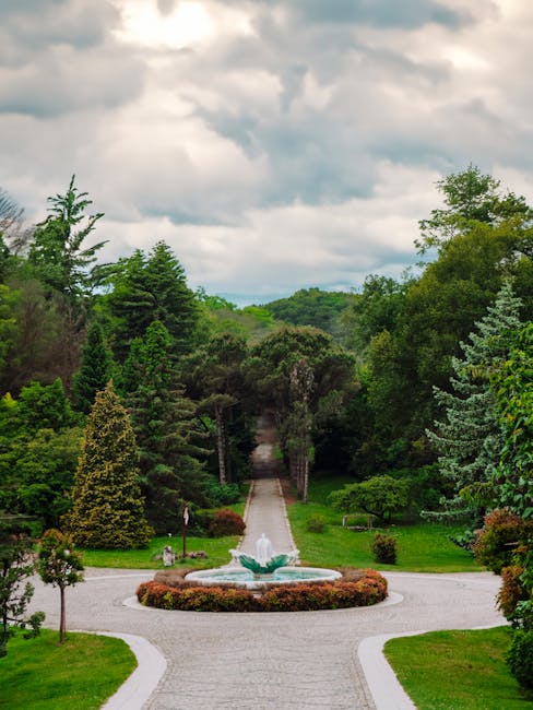 Allée bordée d'arbres menant à une fontaine, parc verdoyant de Crète