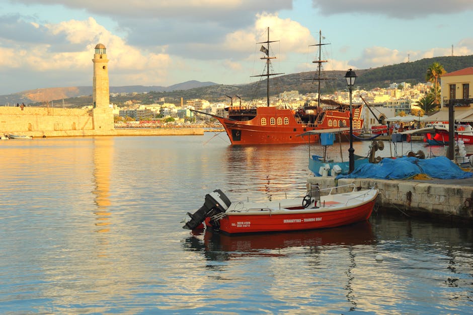 Port na Krecie z drewnianym statkiem i widoczną latarnią morską