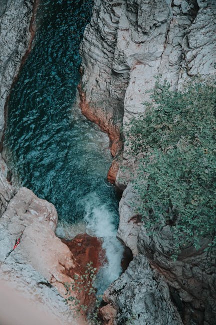 Cascade turquoise se faufilant entre falaises calcaires dans une gorge crétoise