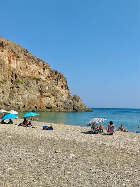 Kiezelstrand met parasols en hoge kliffen aan de kust van Kreta